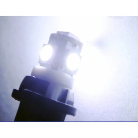 Close-up of a car headlight bulb with a white light on a blurred background