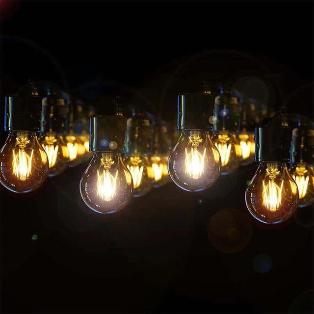 String of lit light bulbs against a dark background