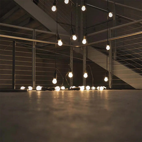 String of light bulbs hanging from the ceiling in a dark room.