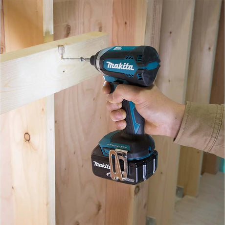 Person using a Makita cordless drill on wooden planks