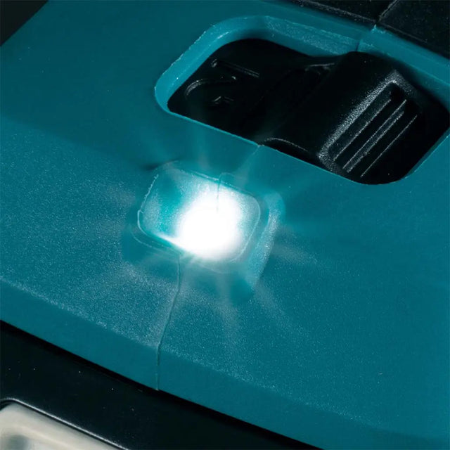 Close-up of a teal power tool with a black switch and a bright white LED light turned on, casting a glow on the surrounding plastic.