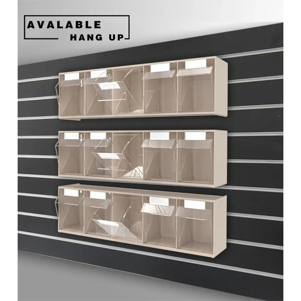 Three beige wall-mounted display racks with clear plastic bins, shown hanging on a black slatwall. A text label in the top left reads 'AVAILABLE HANG UP'.