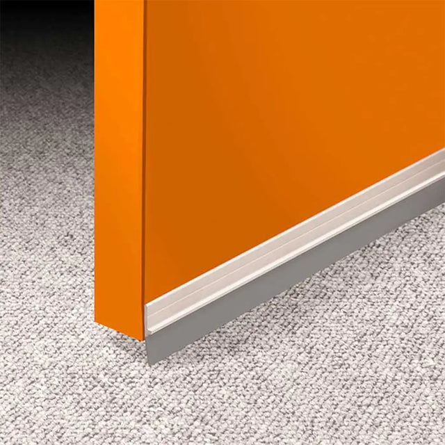 Close-up of an orange cabinet corner with a white base on a gray carpeted floor.