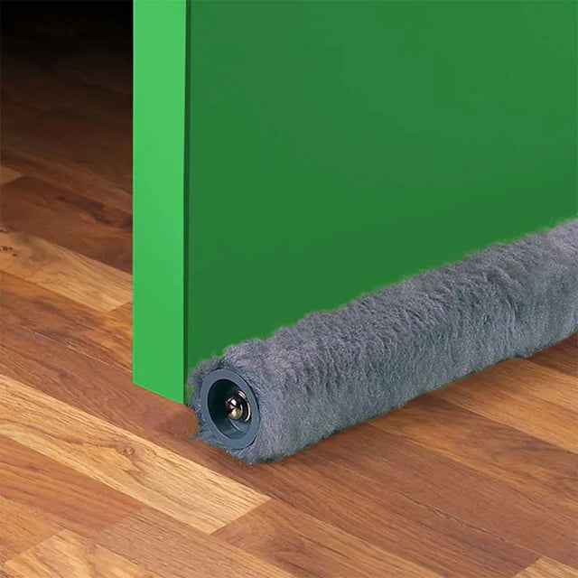 Gray carpeted door stopper on a wooden floor next to a green door