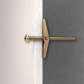 Gold toggle bolt on a gray and white background