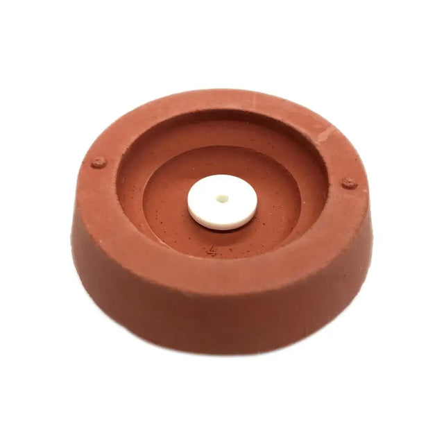 Terracotta-colored candle holder with a white candle on a white background