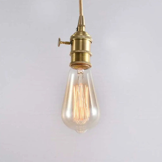 Vintage-style light bulb with brass fitting on a plain background