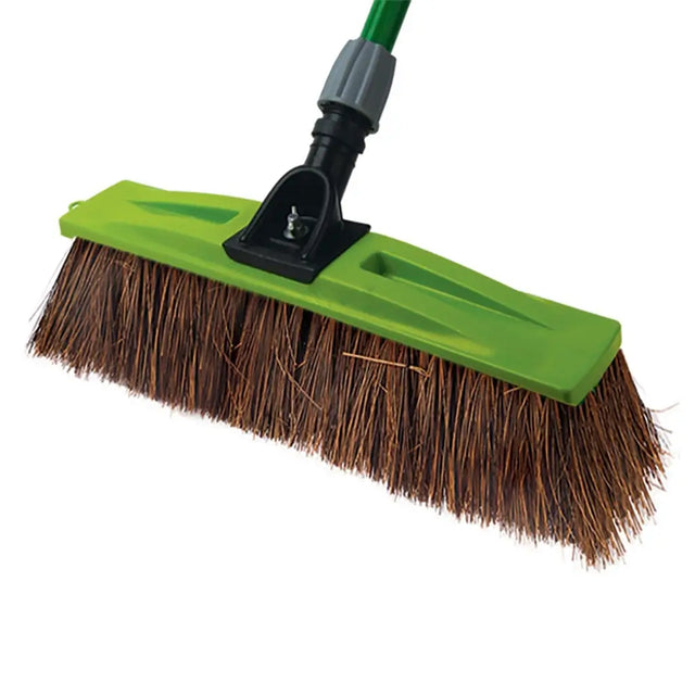 Green push broom with brown bristles on a white background