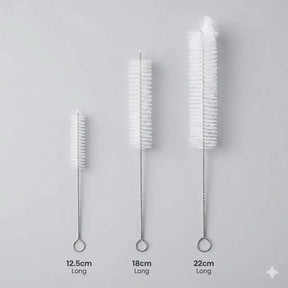 Three bottle brushes of different lengths on a gray background
