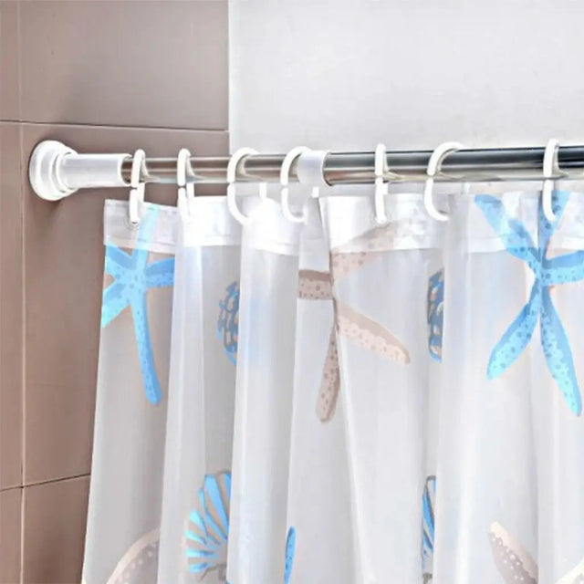 Shower curtain with starfish pattern hanging on a rod against a tiled wall.