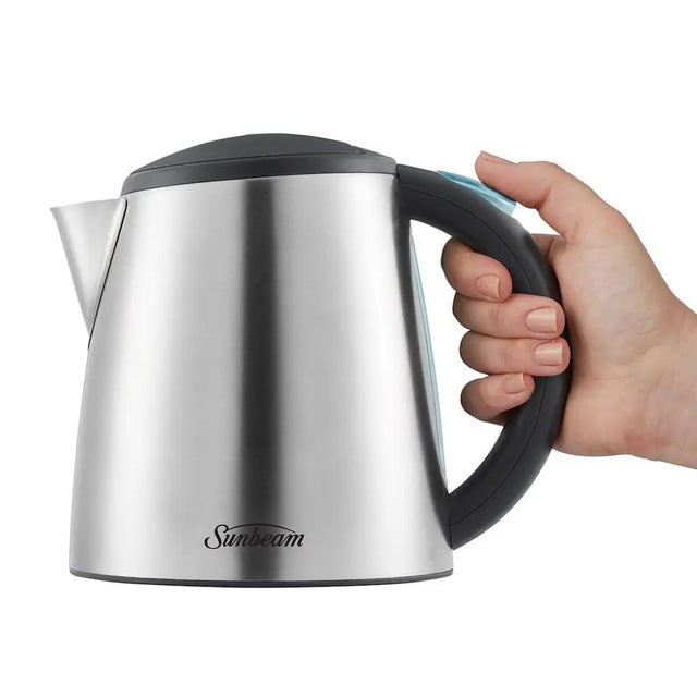 Silver electric kettle with black handle held by a hand on a white background, featuring the Sunbeam brand.