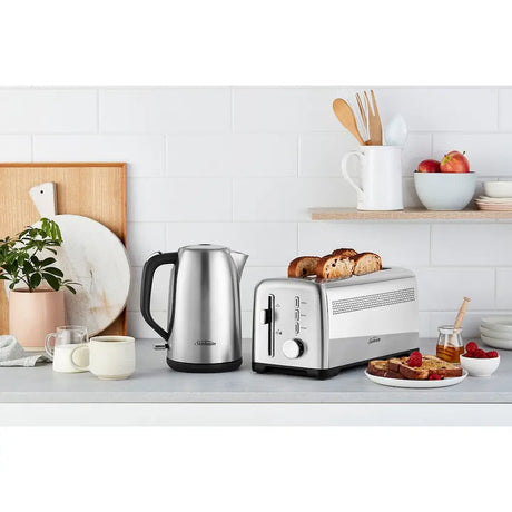 Kitchen counter with a toaster, kettle, and breakfast items on a white tiled wall background