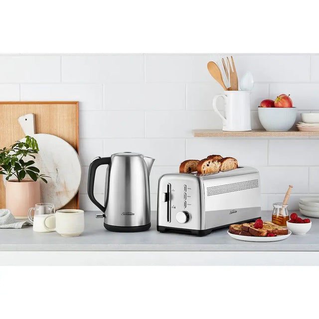 Kitchen counter with a toaster, kettle, and breakfast items on a white tiled wall background