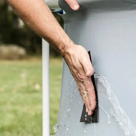 Person applying a sealant strip to a metal surface outdoors