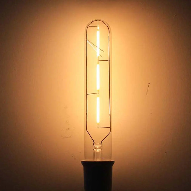 Vintage-style light bulb emitting a warm glow against a plain background