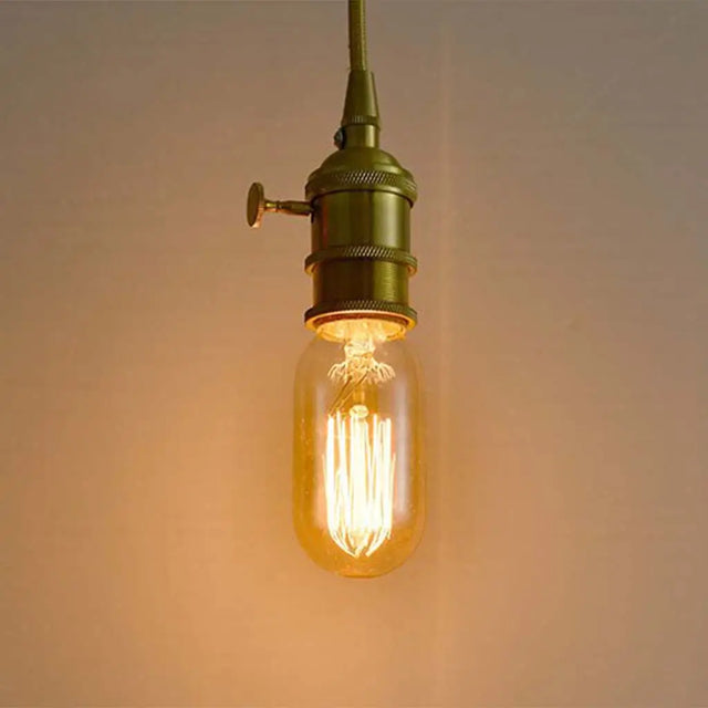 Vintage-style light bulb with green metal fixture on a plain background