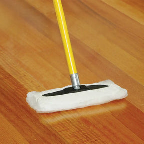 Mop with a white pad and yellow handle cleaning a wooden floor.