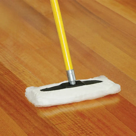 Mop with a white pad and yellow handle cleaning a wooden floor.