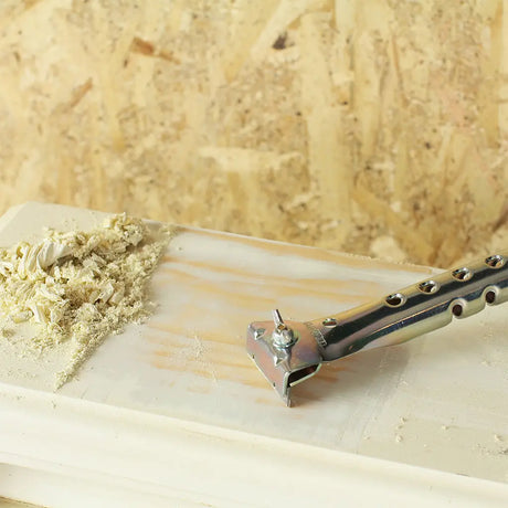 Metal tool with wooden handle on a wooden surface with wood shavings.
