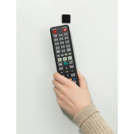 Hand holding a remote control with a white background
