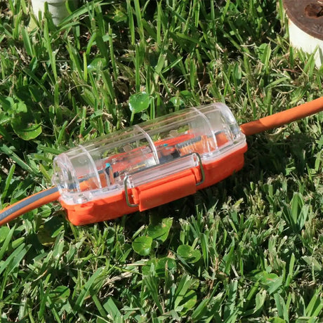 Orange electrical connector on grass