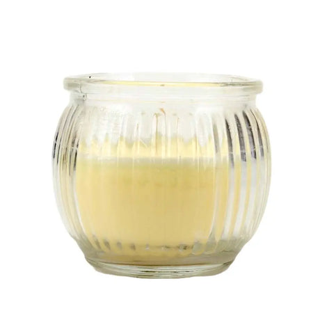 Glass candle holder with a lit candle inside on a white background