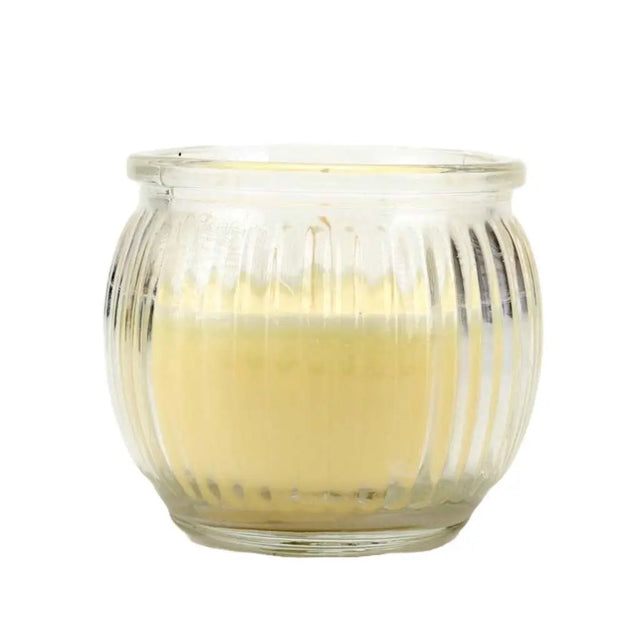 Glass candle holder with a lit candle inside on a white background