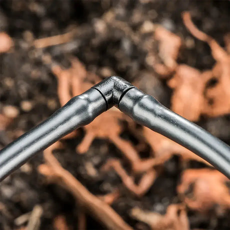 Close-up of irrigation pipe fitting against a blurred natural background